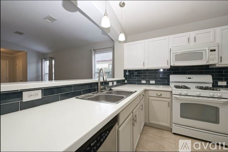 A kitchen with white cabinets and black appliances.