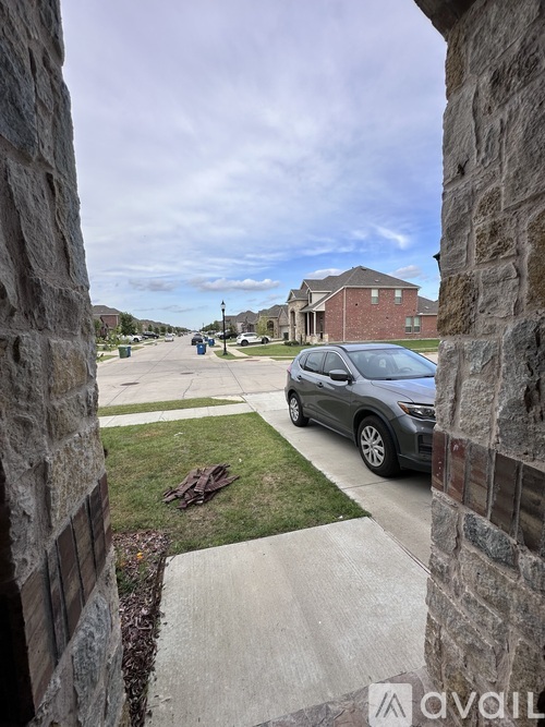 A silver car is parked on a driveway.