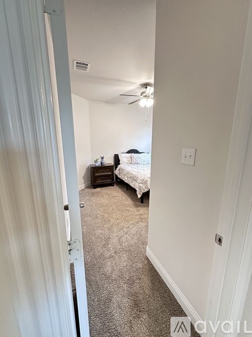 A room with a bed and a ceiling fan.