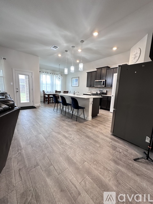 A kitchen with a dining table and chairs in the middle of the room.