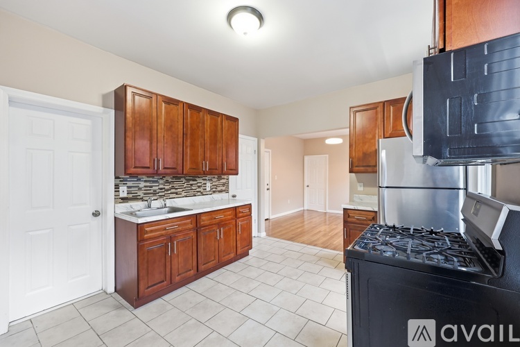 A kitchen with wooden cabinets and a black stove top oven.