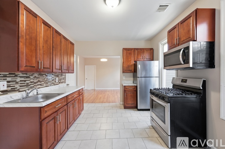 A kitchen with brown cabinets and a black stove top oven.