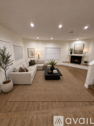 A living room with a couch, a coffee table, and a fireplace.