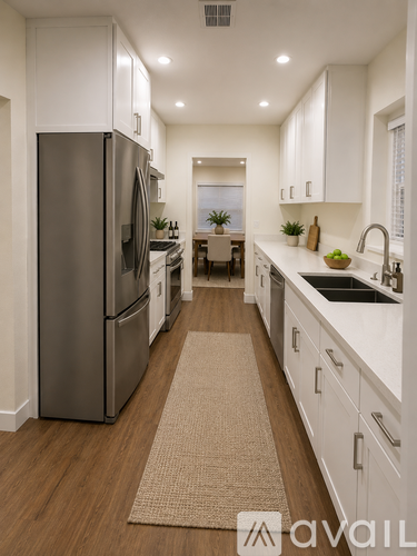 A modern kitchen with a refrigerator, sink, and cabinets.