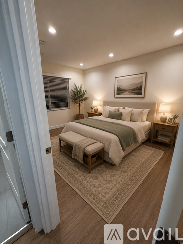 A bedroom with a large bed and a small tree in the corner.