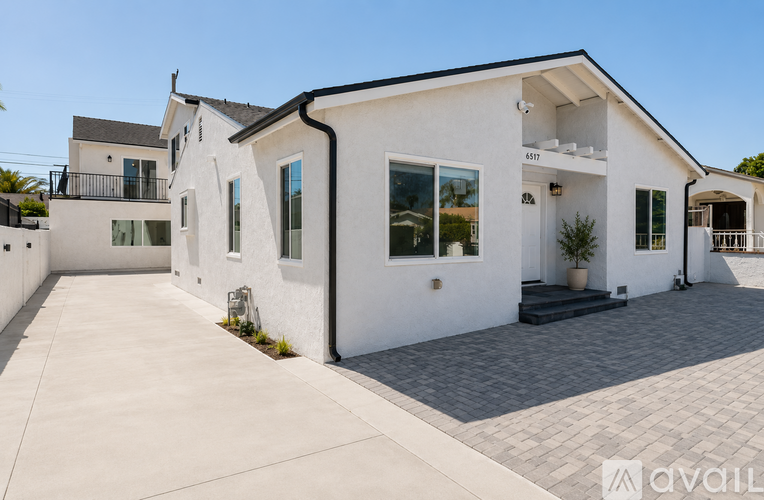 A modern house with a white exterior and a black roof is shown.