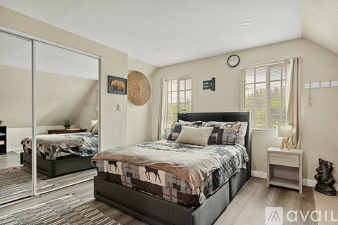 A bedroom with a large bed and a mirror on the wall.