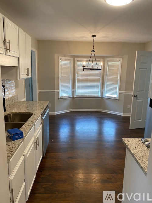 A kitchen with white cabinets and a granite countertop.