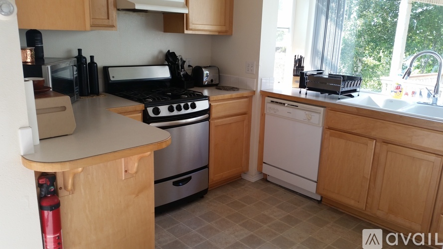 A kitchen with wooden cabinets and a white dishwasher.