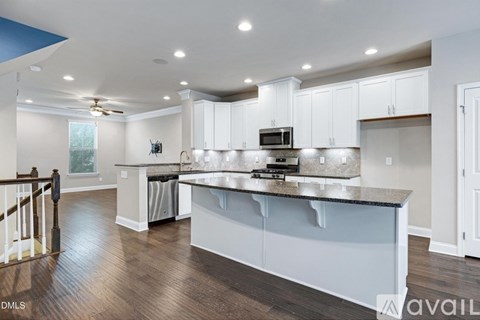A kitchen with white cabinets and a granite countertop.