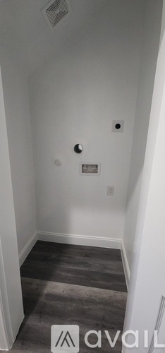A room with a white wall and a grey floor.