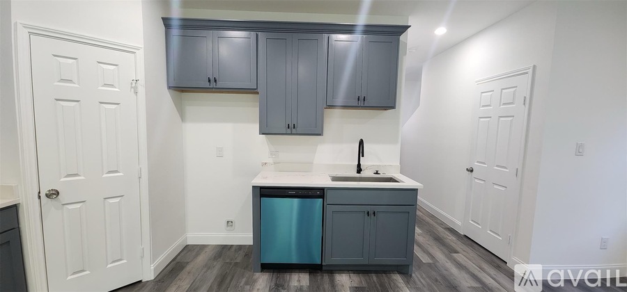 A kitchen with a white countertop and a blue trash can.