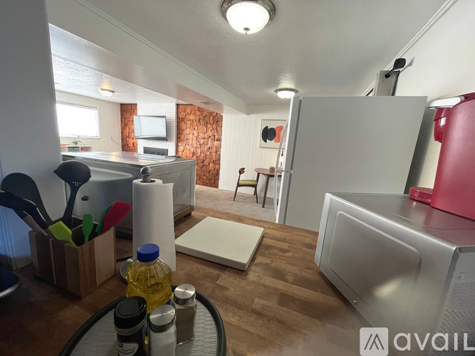 A kitchen with a refrigerator, table, and chairs.