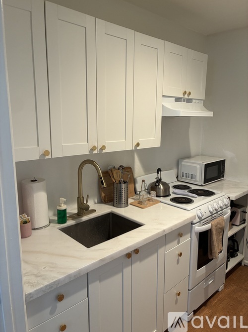 A kitchen with white cabinets and appliances.