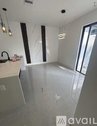 A room with a marble floor and a kitchen island with a sink.