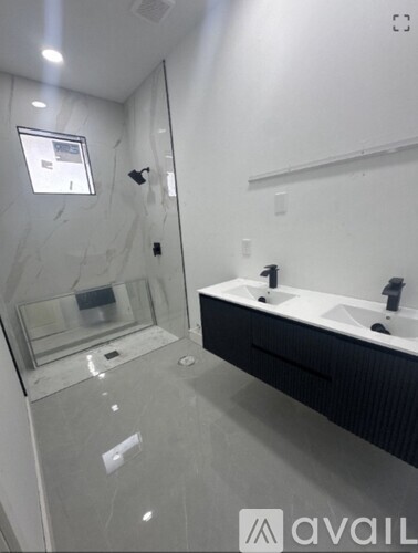 A bathroom with a glass shower stall and a sink.