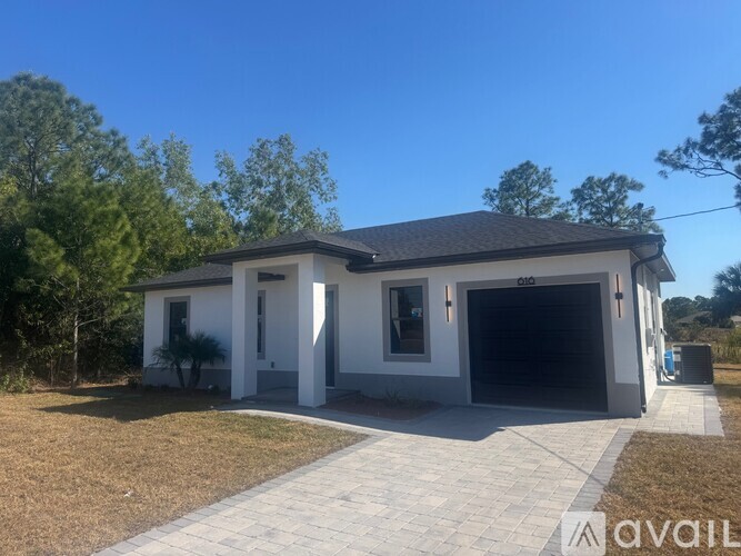 A two-story house with a garage is available for sale.