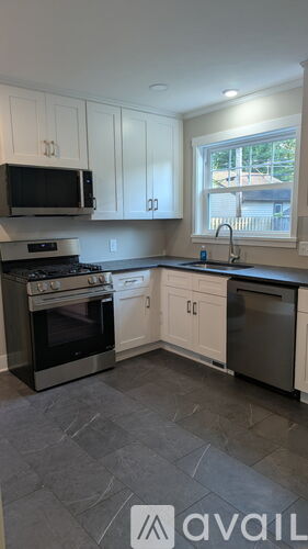 A kitchen with white cabinets and a black stove top oven.