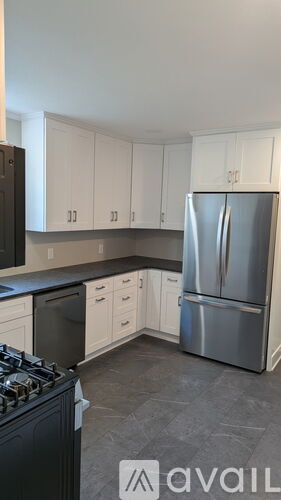 A kitchen with a stove, refrigerator, and cabinets.