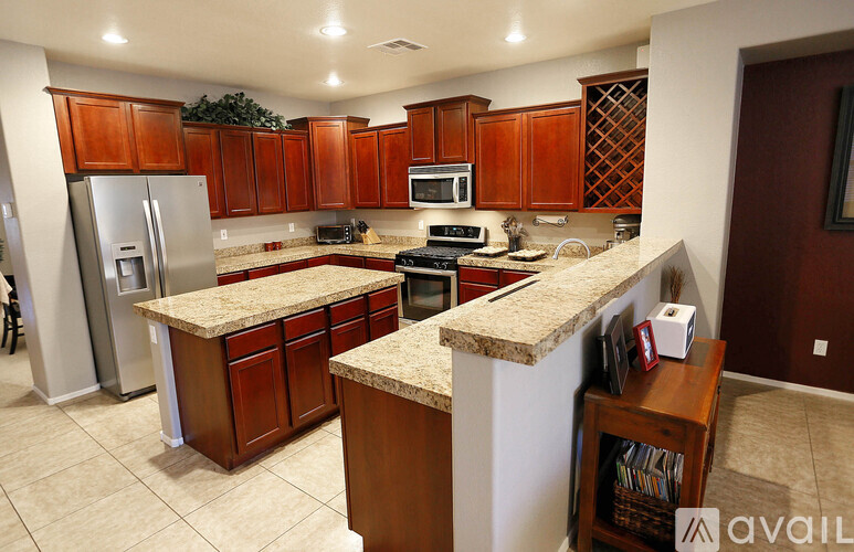 A kitchen with brown cabinets and granite countertops.