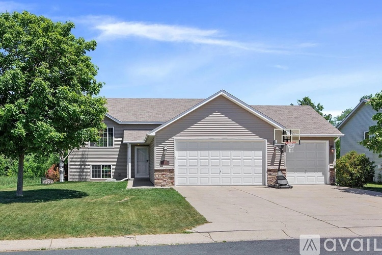 A house with a garage and a tree in front.
