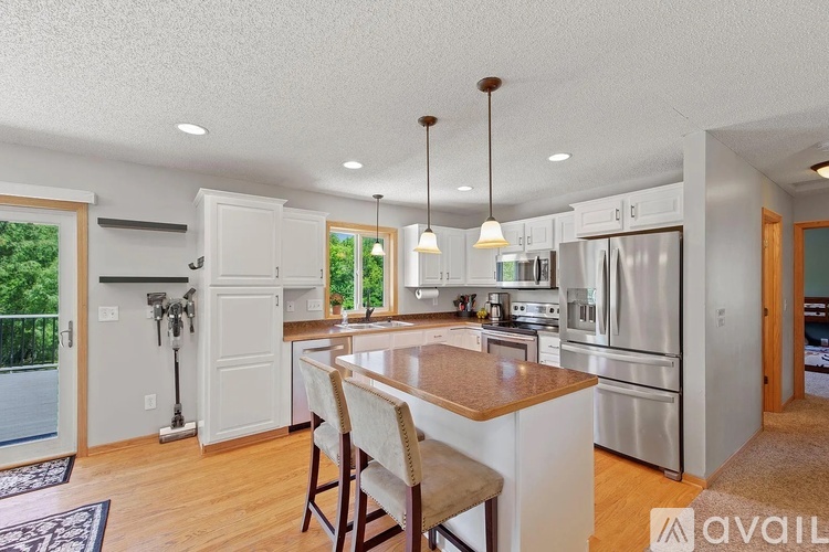 A kitchen with a center island and pendant lights.