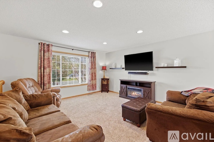 A living room with a brown couch and a fireplace.