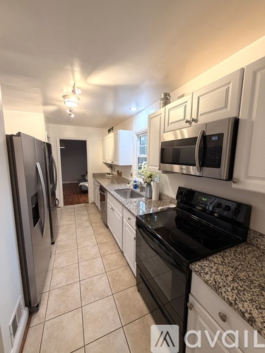A kitchen with black appliances and white cabinets.
