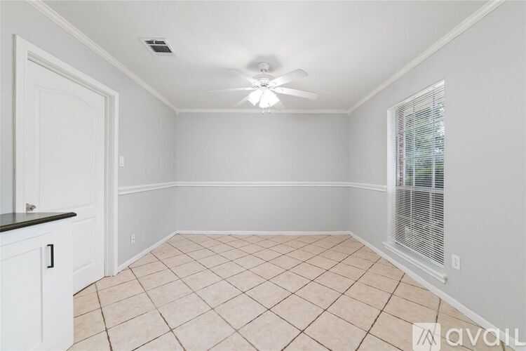 A room with a ceiling fan and tiled floor.