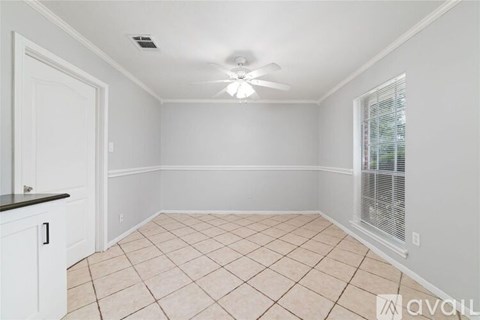 A room with a ceiling fan and tiled floor.