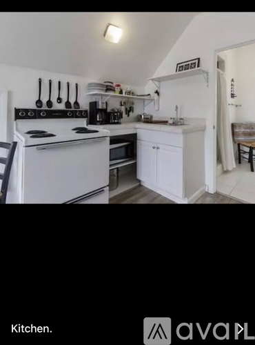 A kitchen with white appliances and cabinets.