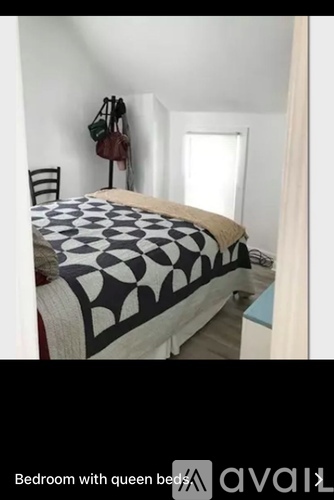 A bedroom with a bed and a chair.