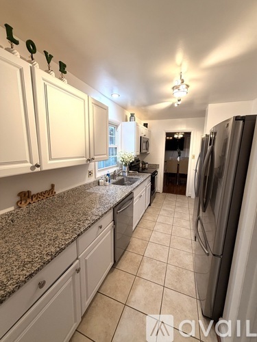 A kitchen with granite countertops and white cabinets.