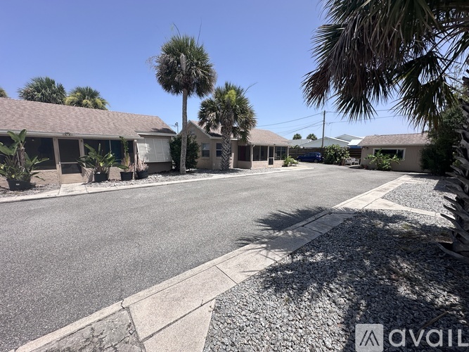 A sunny day at a residential area with houses and palm trees.