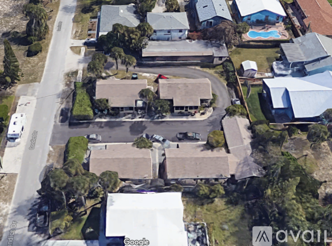 A satellite image of a residential area with houses and a swimming pool.
