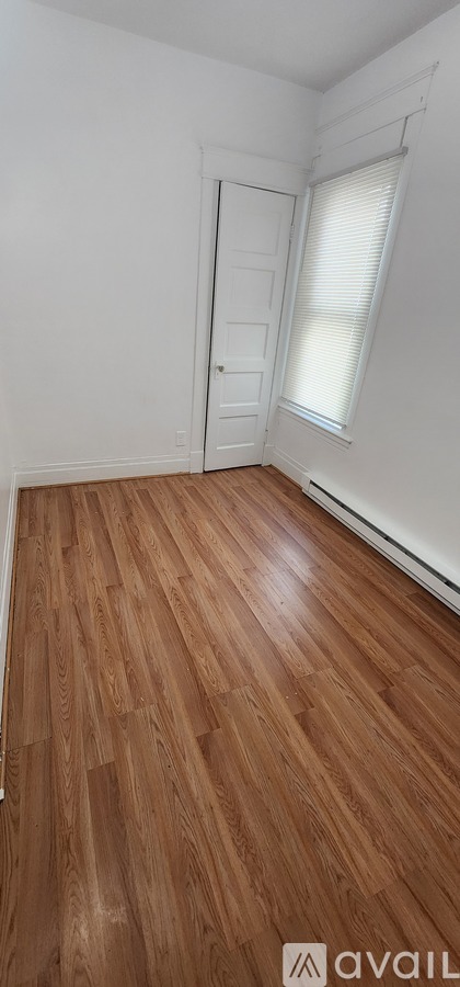 A room with wooden flooring and a white door.
