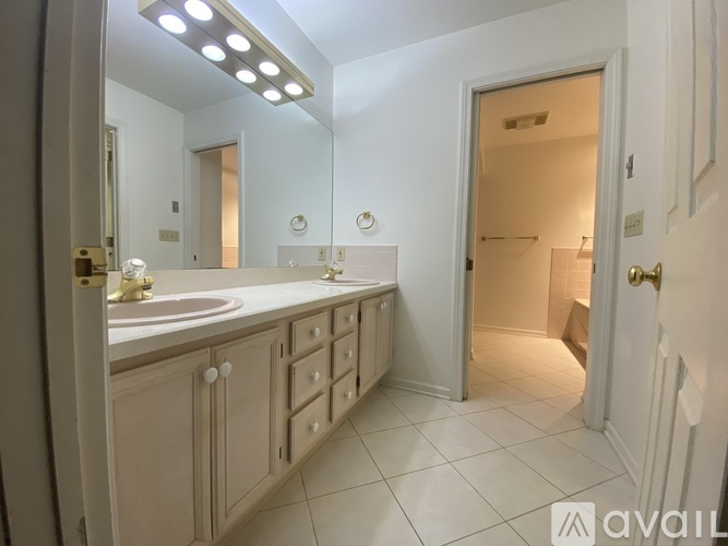 A bathroom with a sink, mirror, and cabinets.