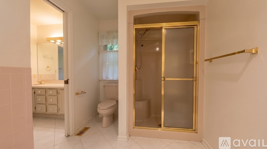 A bathroom with a toilet, sink, and shower.