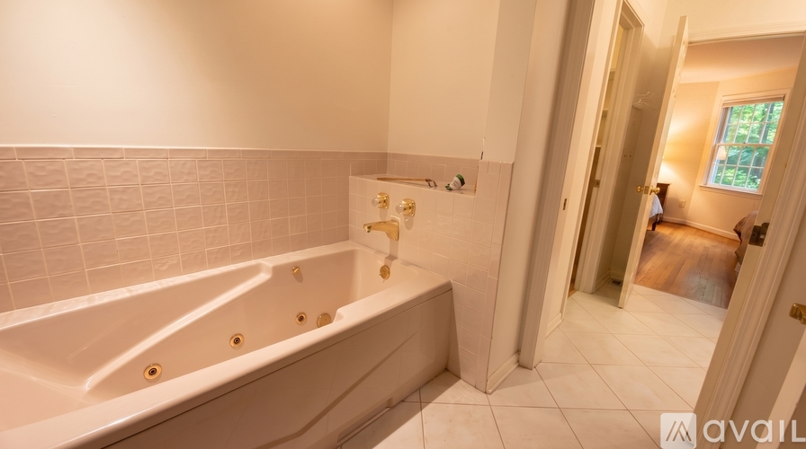 A white bathtub with a shower head and faucet.
