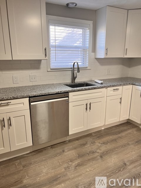 A kitchen with white cabinets and a stainless steel dishwasher.