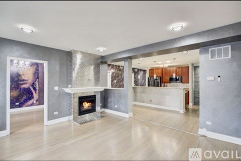 A modern living room with a fireplace and a painting on the wall.