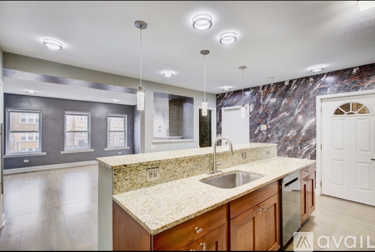 A kitchen with a marble backsplash and wooden cabinets.