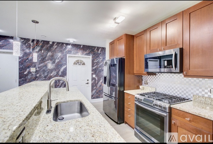 A kitchen with granite countertops and stainless steel appliances.