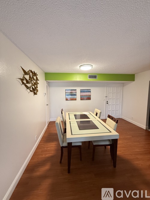 A dining room with a table and chairs.