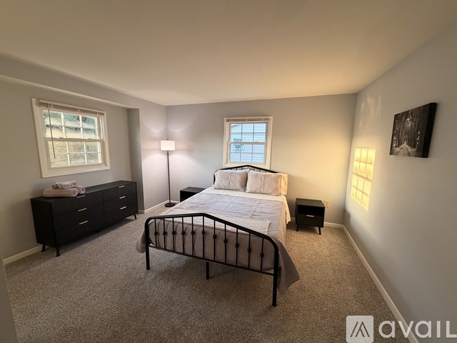 A bedroom with a bed, nightstand, and dresser.