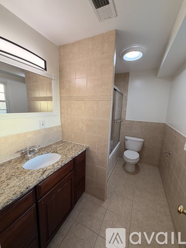 A bathroom with a sink, toilet, and a shower.