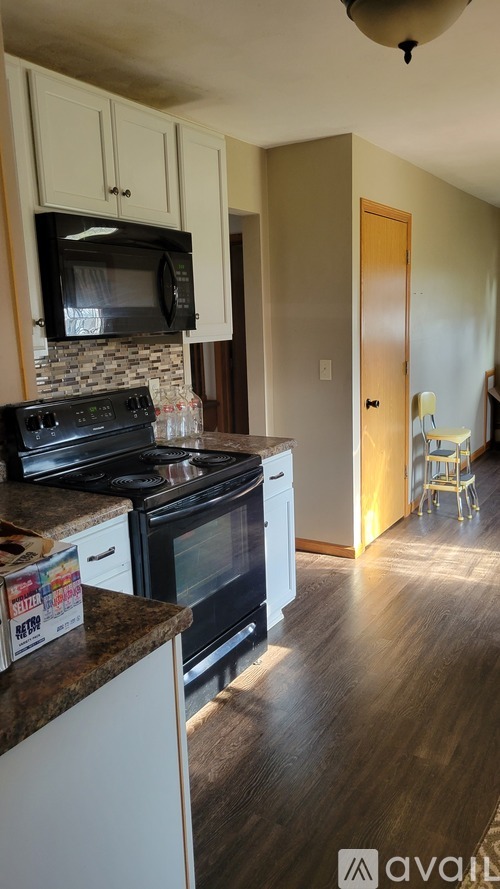 A kitchen with a black microwave above the stove.