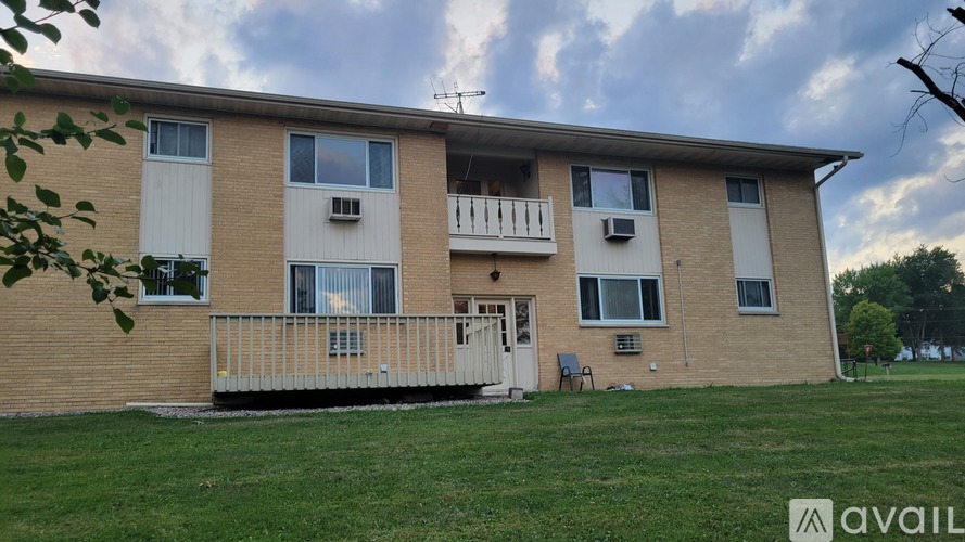 A two-story apartment building with a balcony on the second floor.