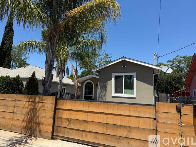 A house with a grey roof and a brown fence.