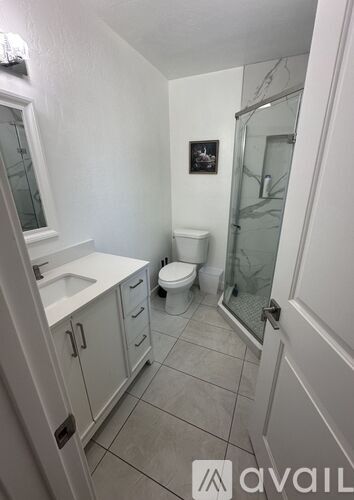 A bathroom with a toilet, sink, and shower.